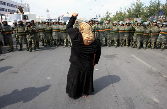 Uyghur woman facing a police cordon during protests in Xinjiang in 2009